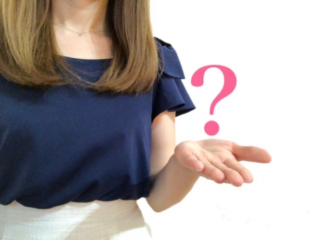 はてなマークを持つ女性